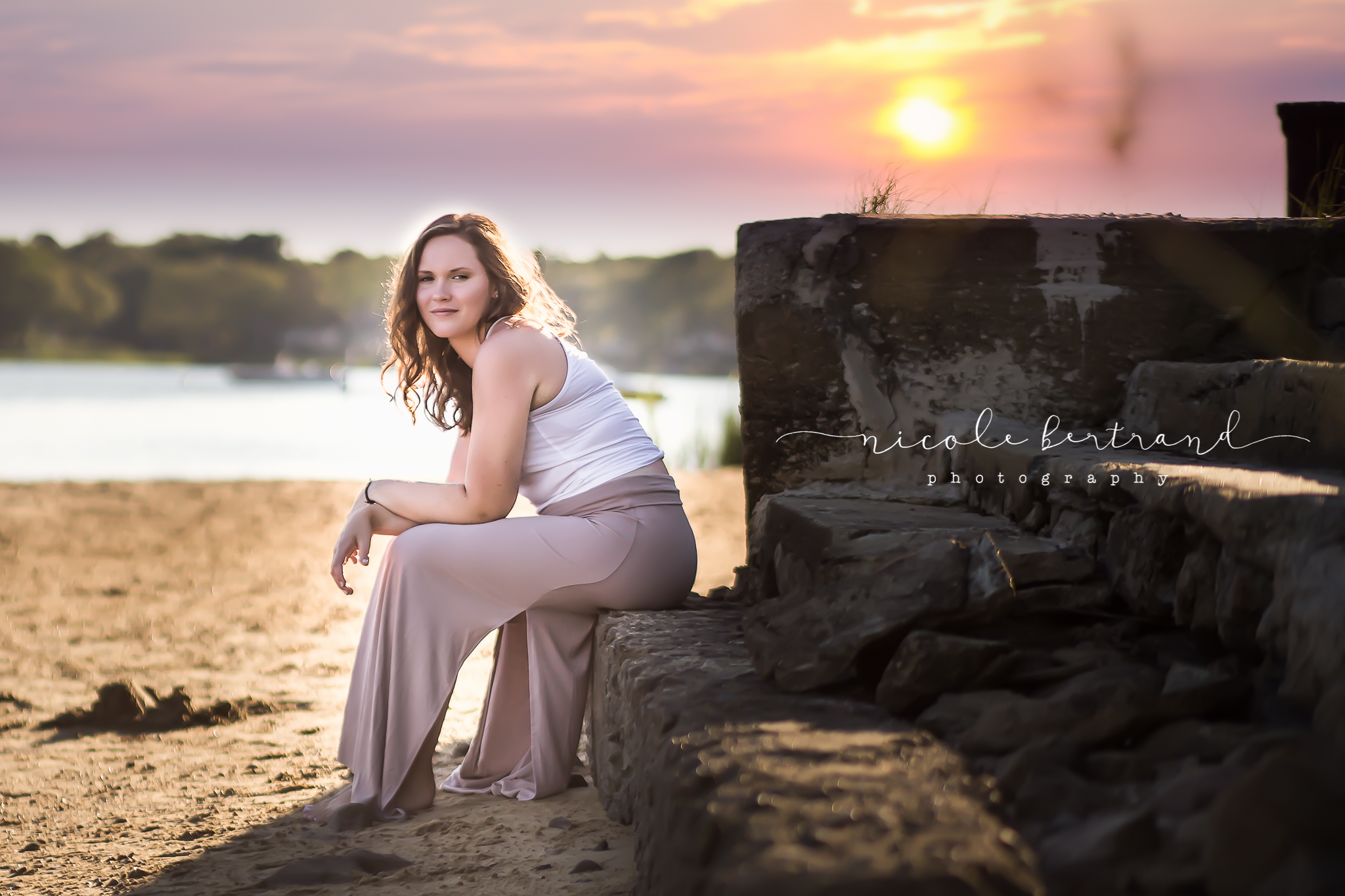 pregnant woman sitting on beach during sunset