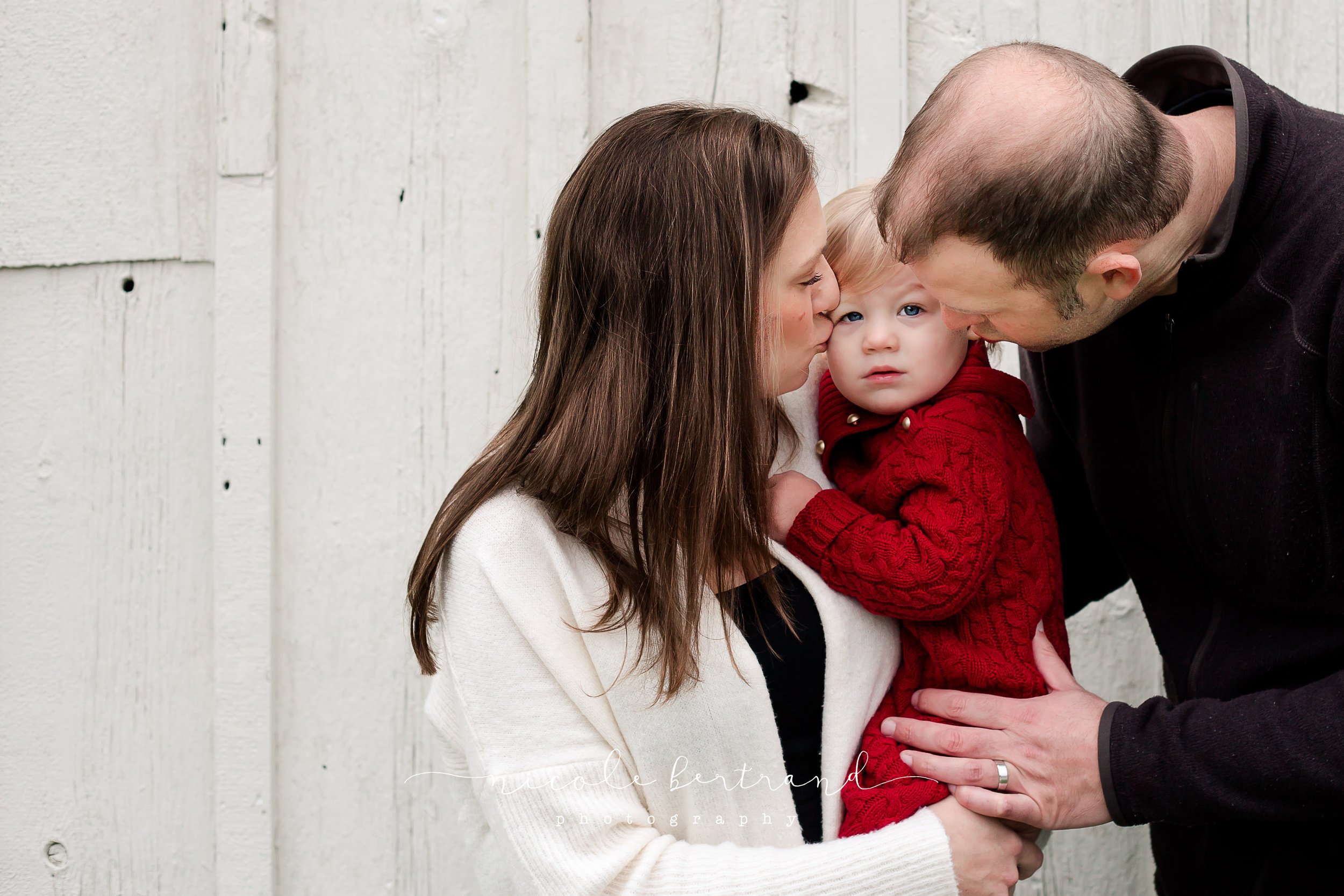 parents kissing baby during lifestyle newborn