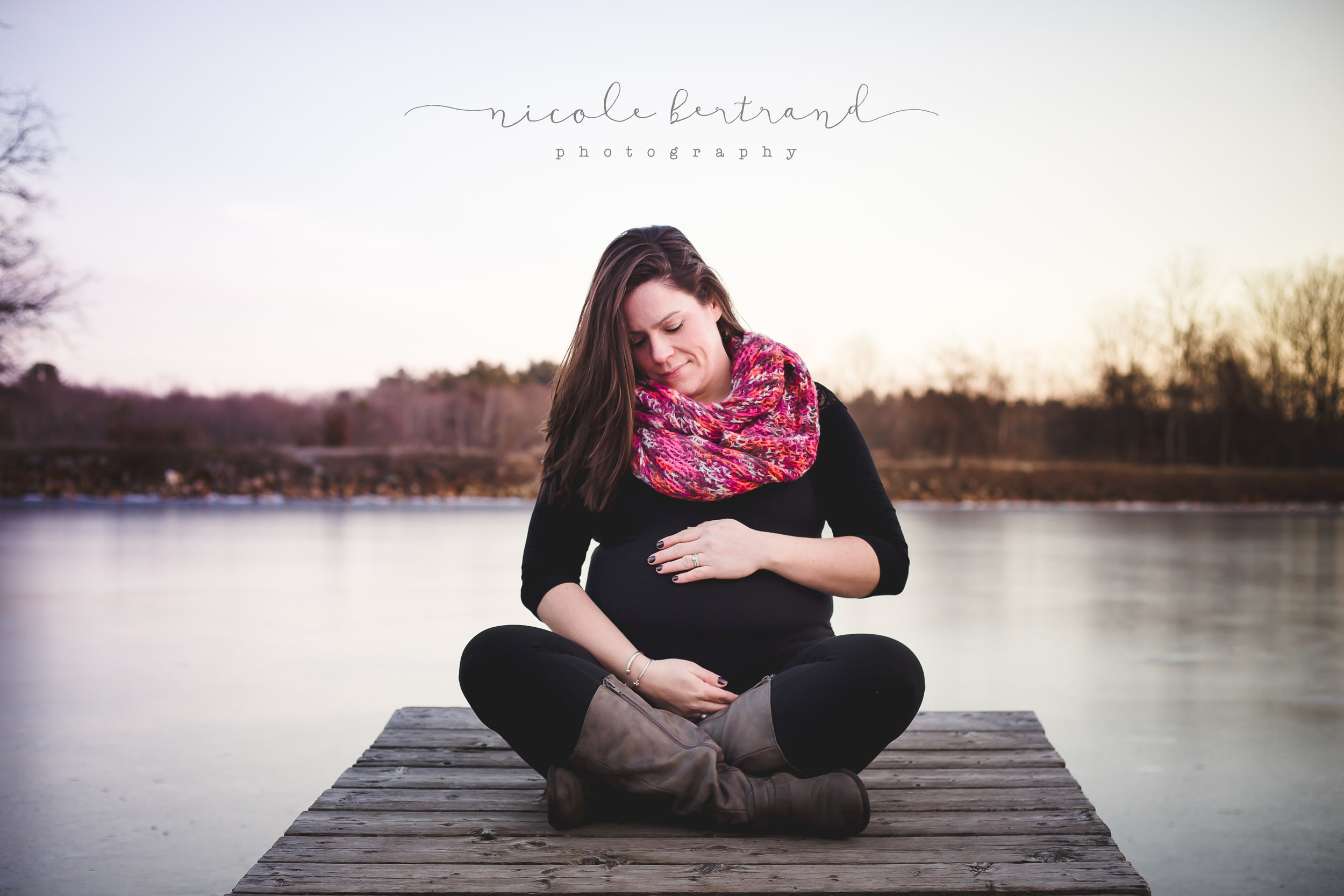 pregnant mom sitting on lake dock during maternity pictures