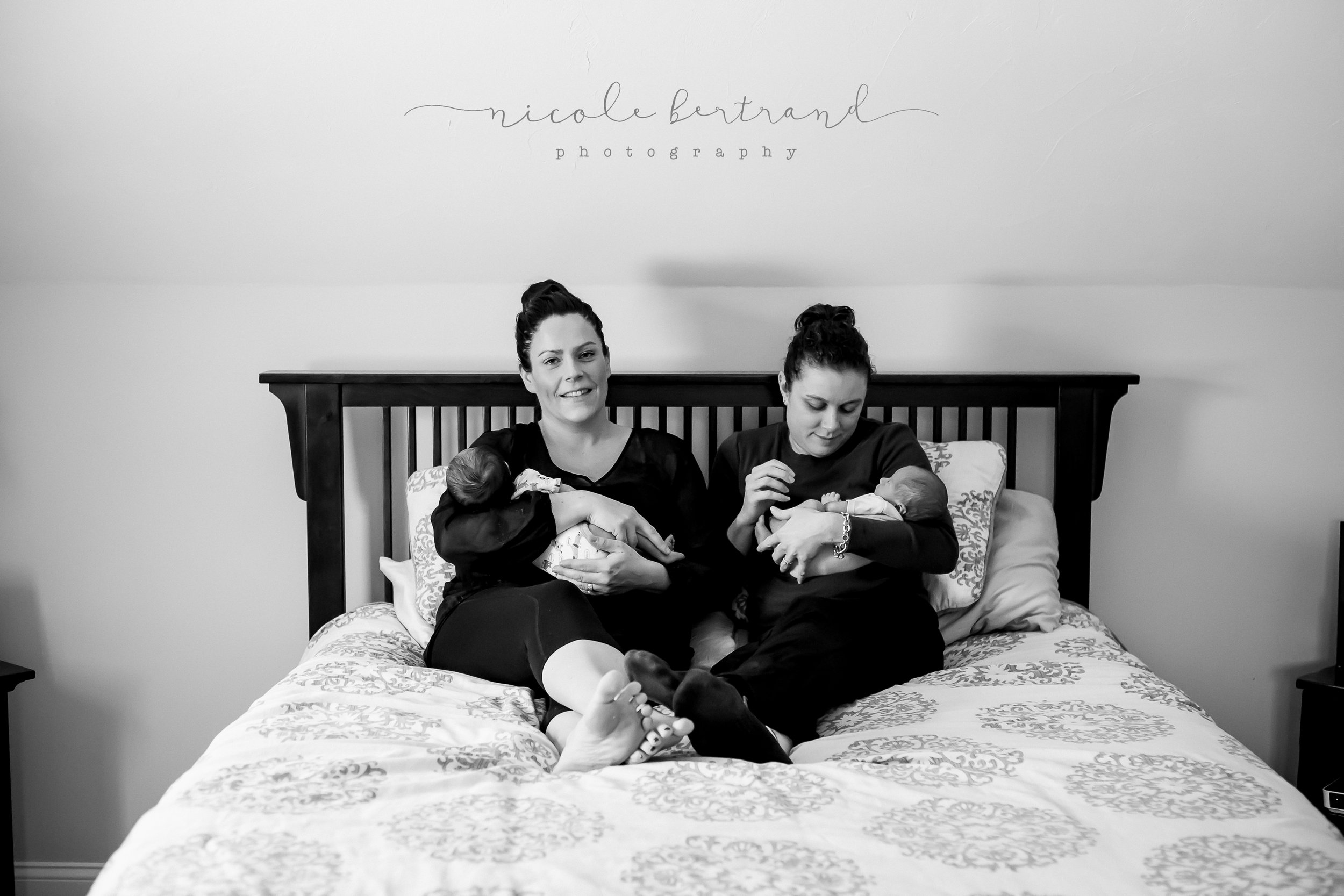 lifestyle newborn LGBTQ sitting in bed with newborn babies