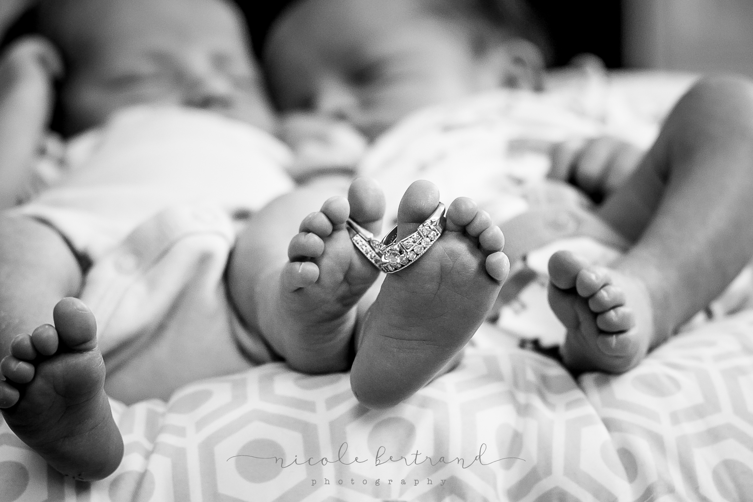 lifestyle newborn twin feet with wedding rings
