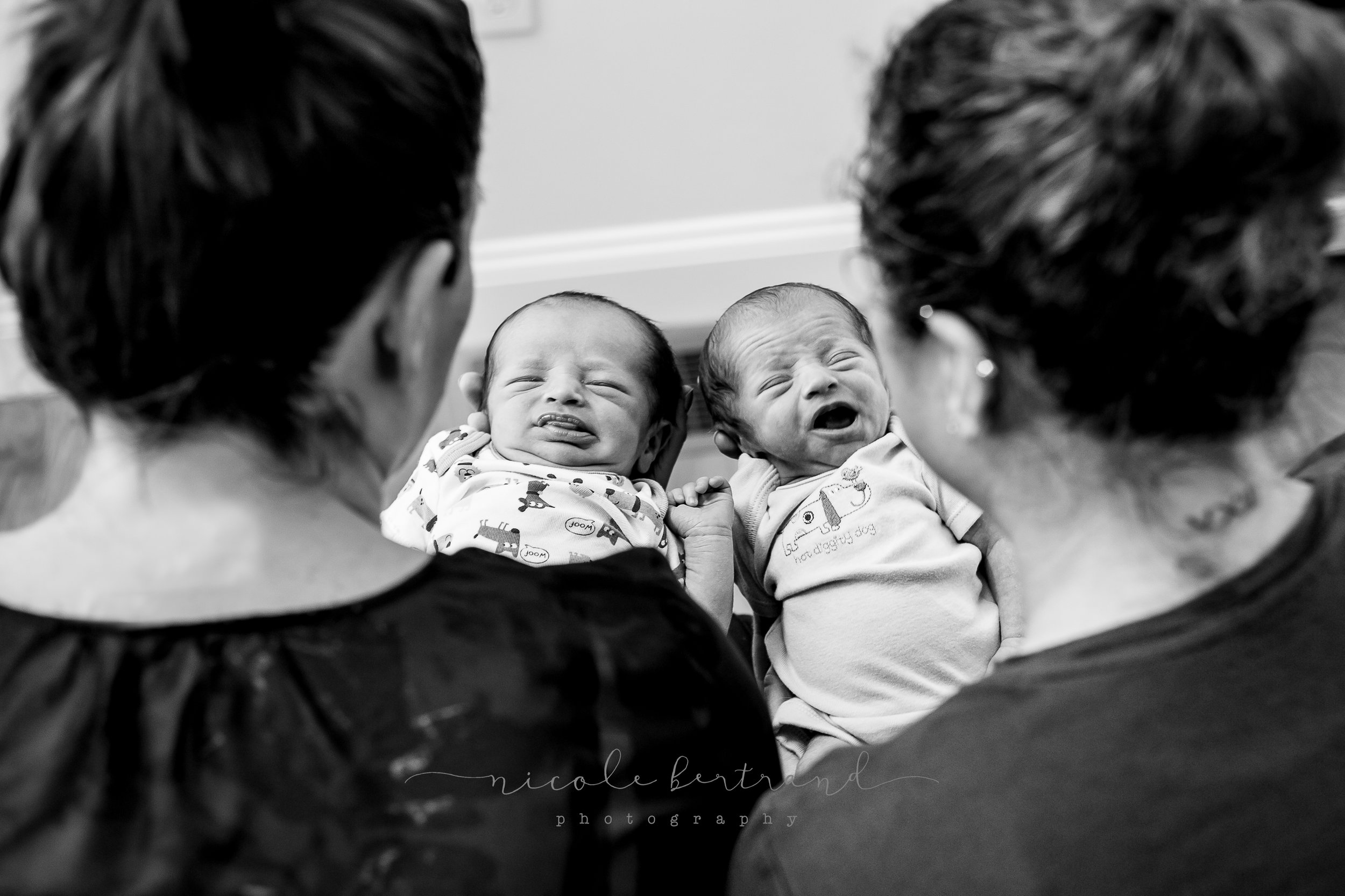 lifestyle newborn LGBTQ parents looking at twins