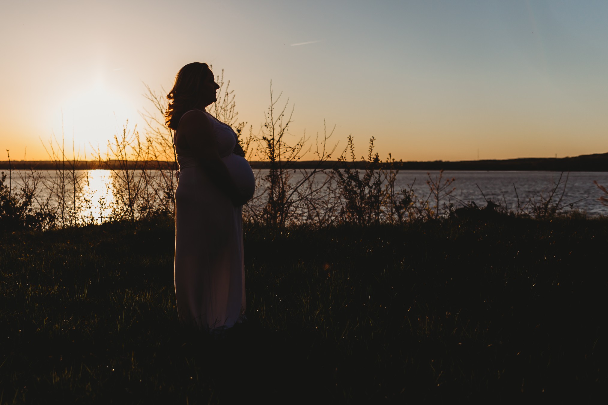 maternity photos of pregnant woman at sunset