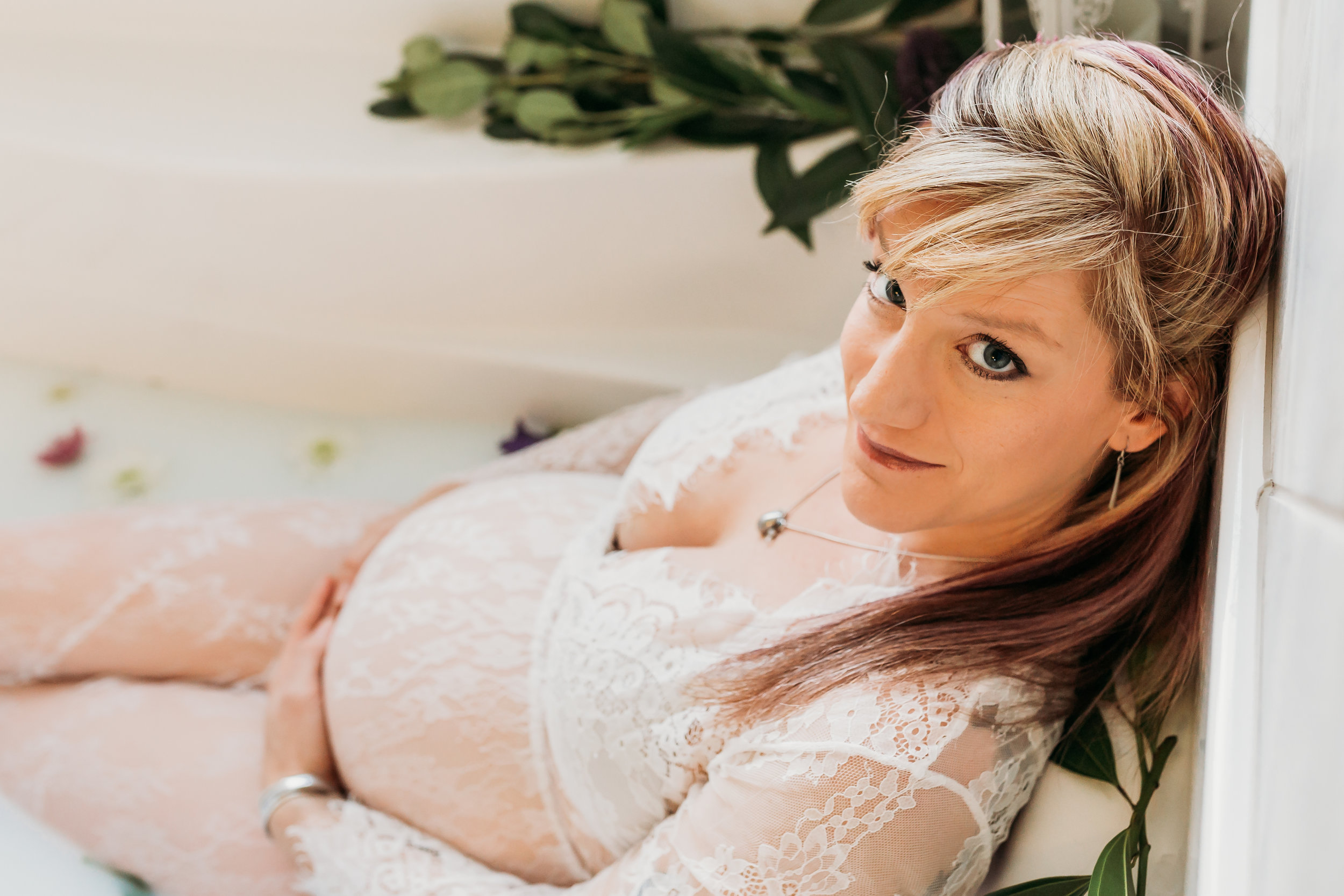 pregnant woman dressed in lace in milk bath