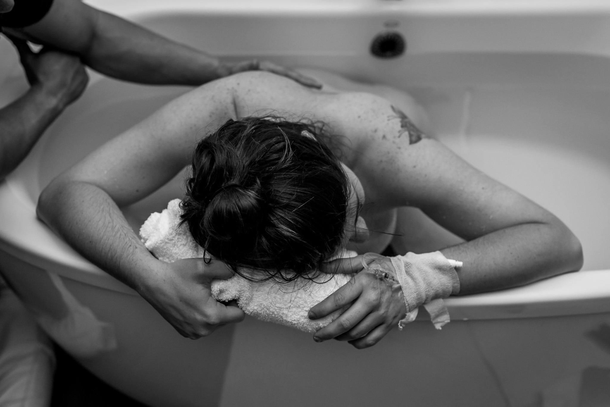 woman rests in between contractions in birth tub