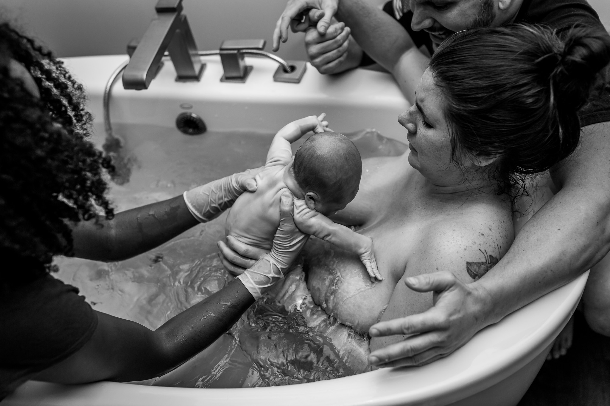 midwife puts baby on moms chest during water birth