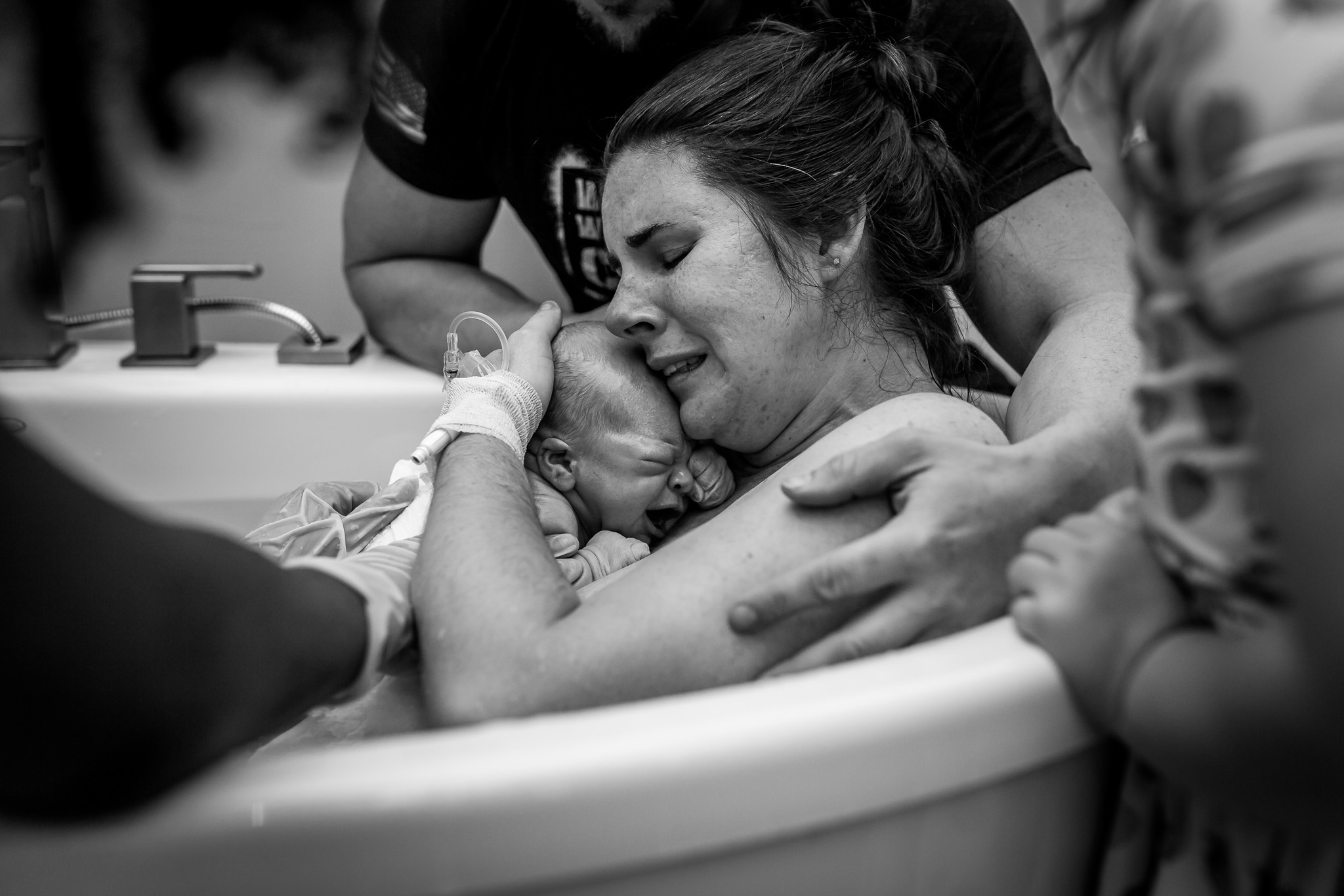 mother embraces newborn after water birth