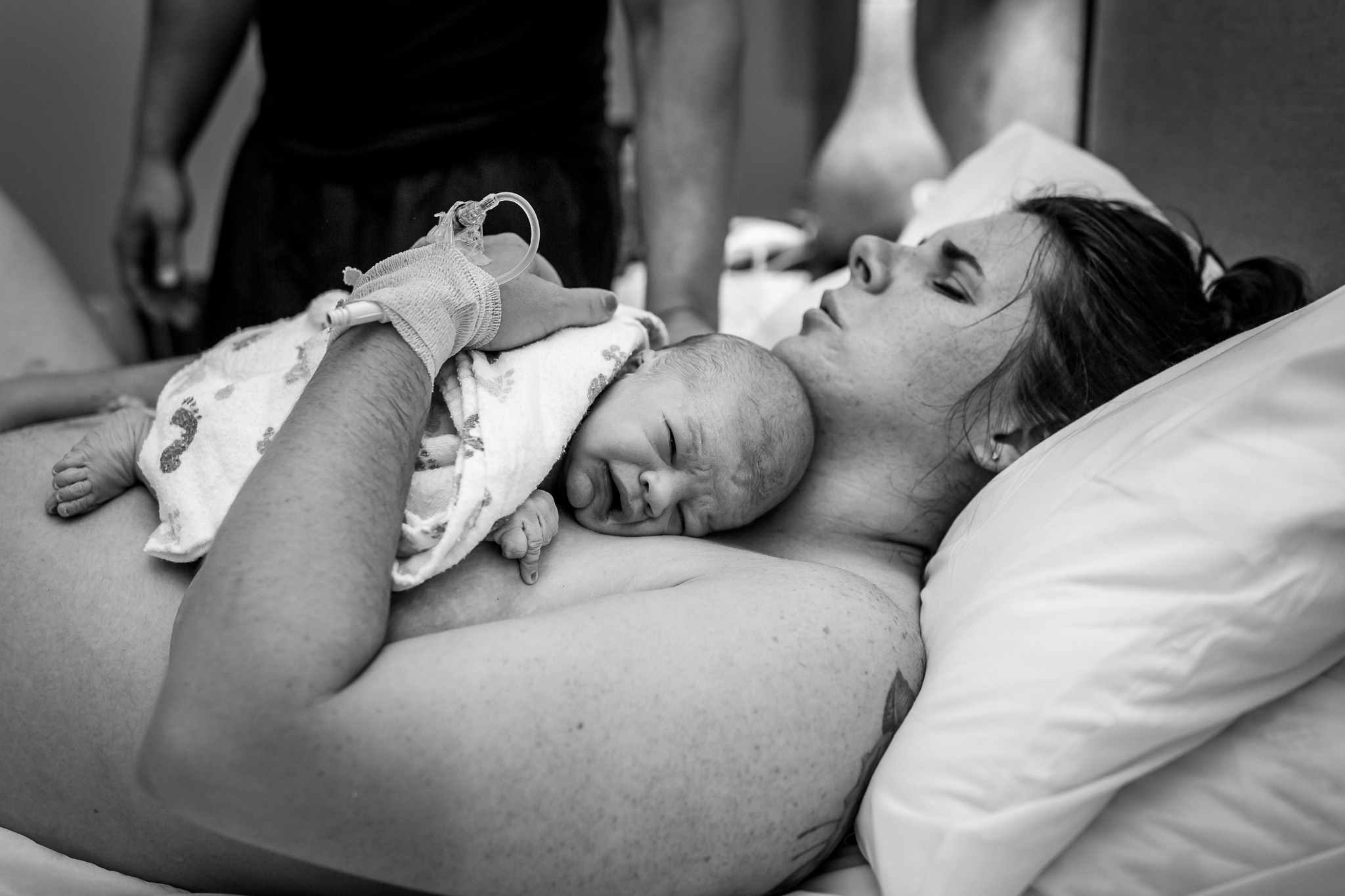 mom hugs son in bed postpartum