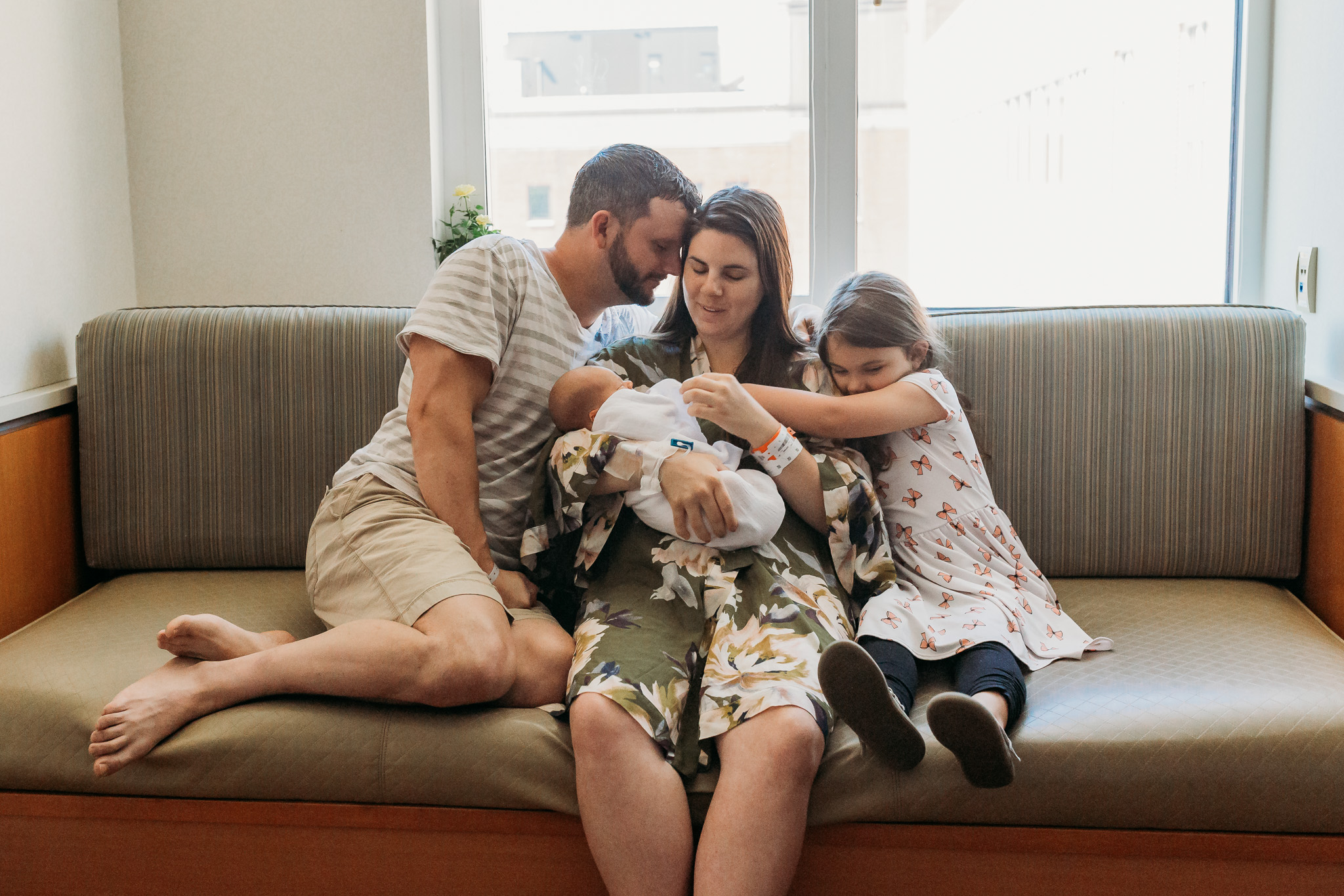family embraces on couch in hospital room
