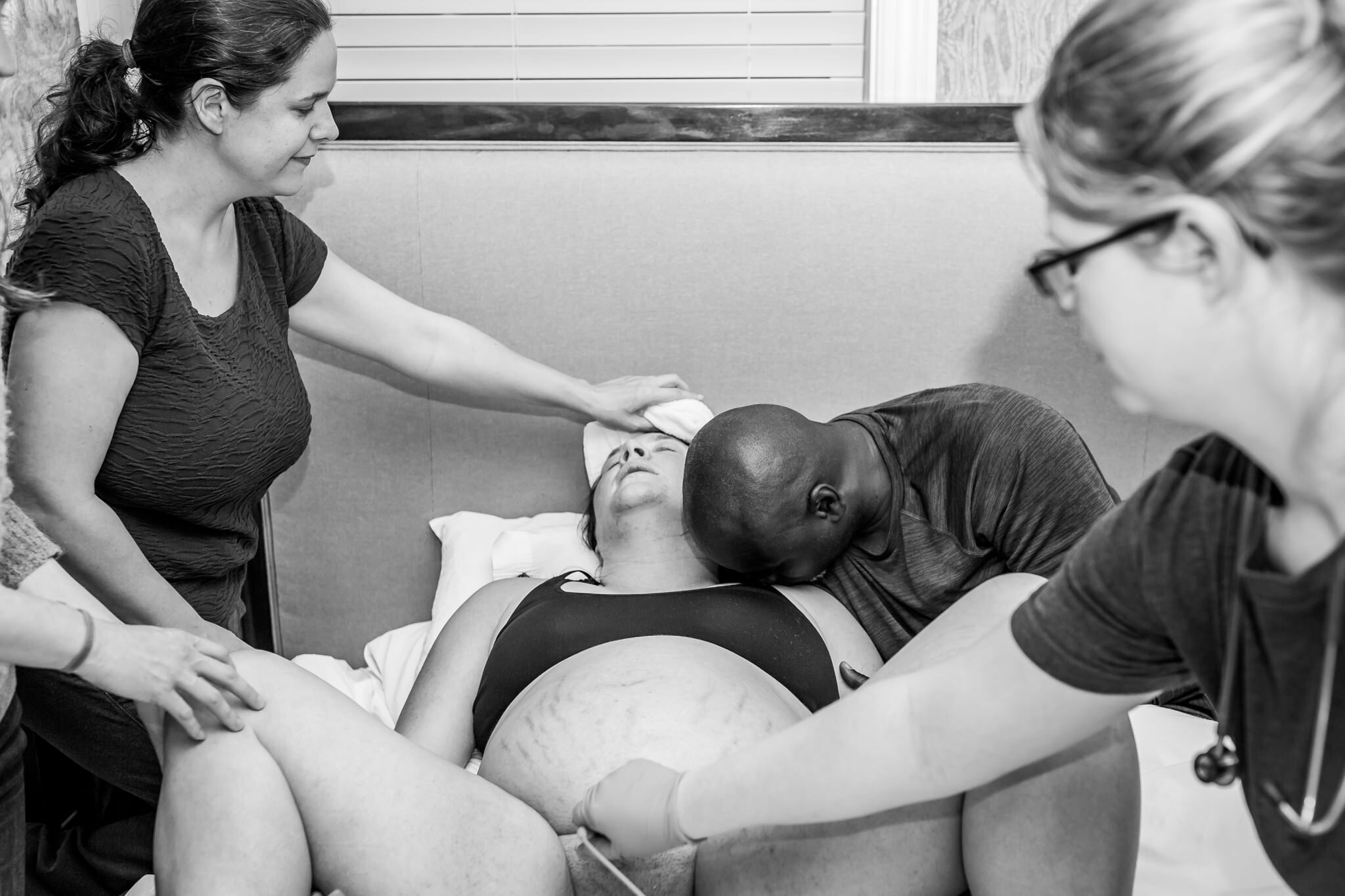doula gives mom a cool compress in between contractions during birth center birth