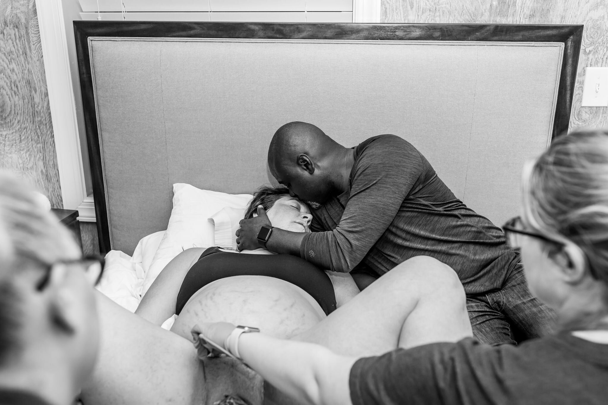 husband kisses wife in between  pushes during birth story birth