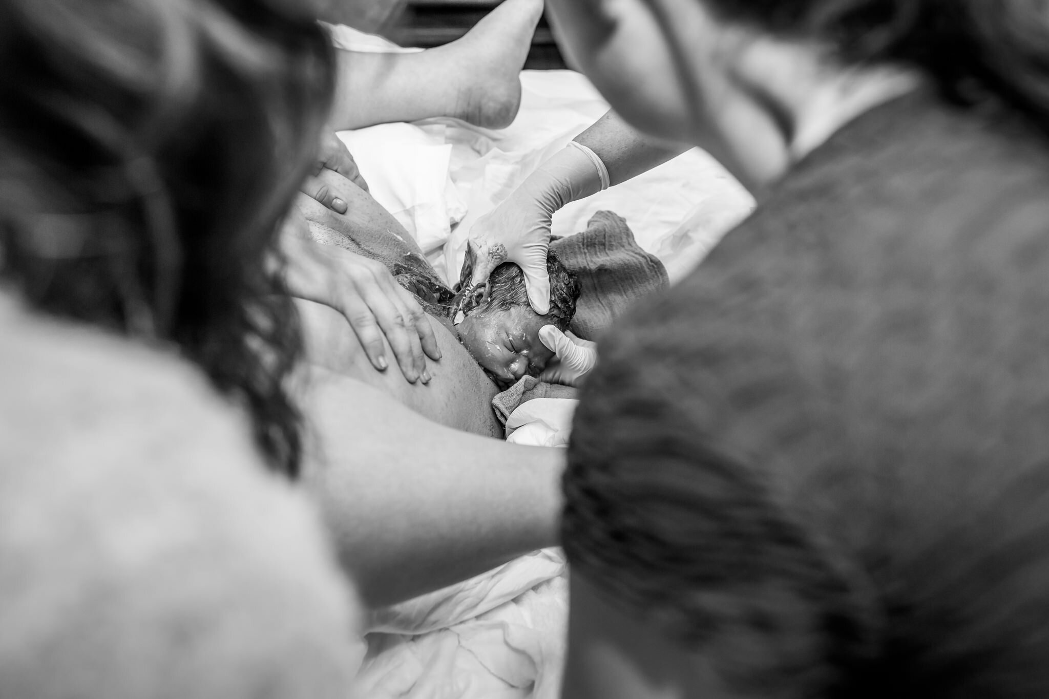 midwife guiding baby out of vagina during birth story birth