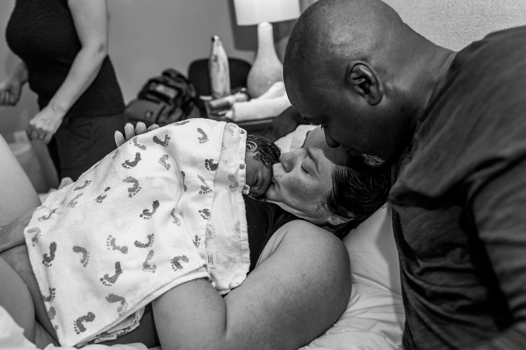 mom kisses newborn postpartum birth