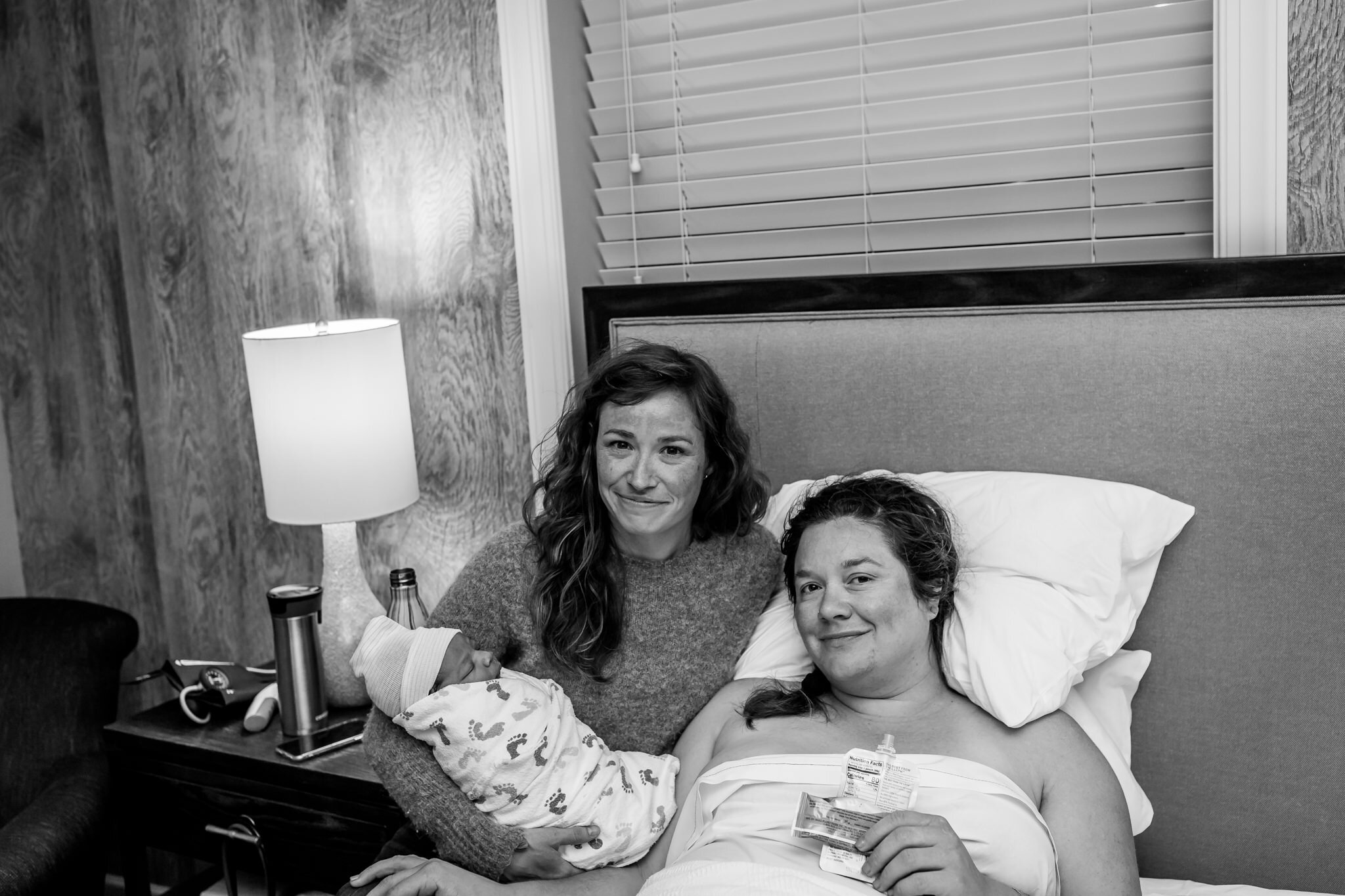 portrait of doula and mom holding newborn after birth
