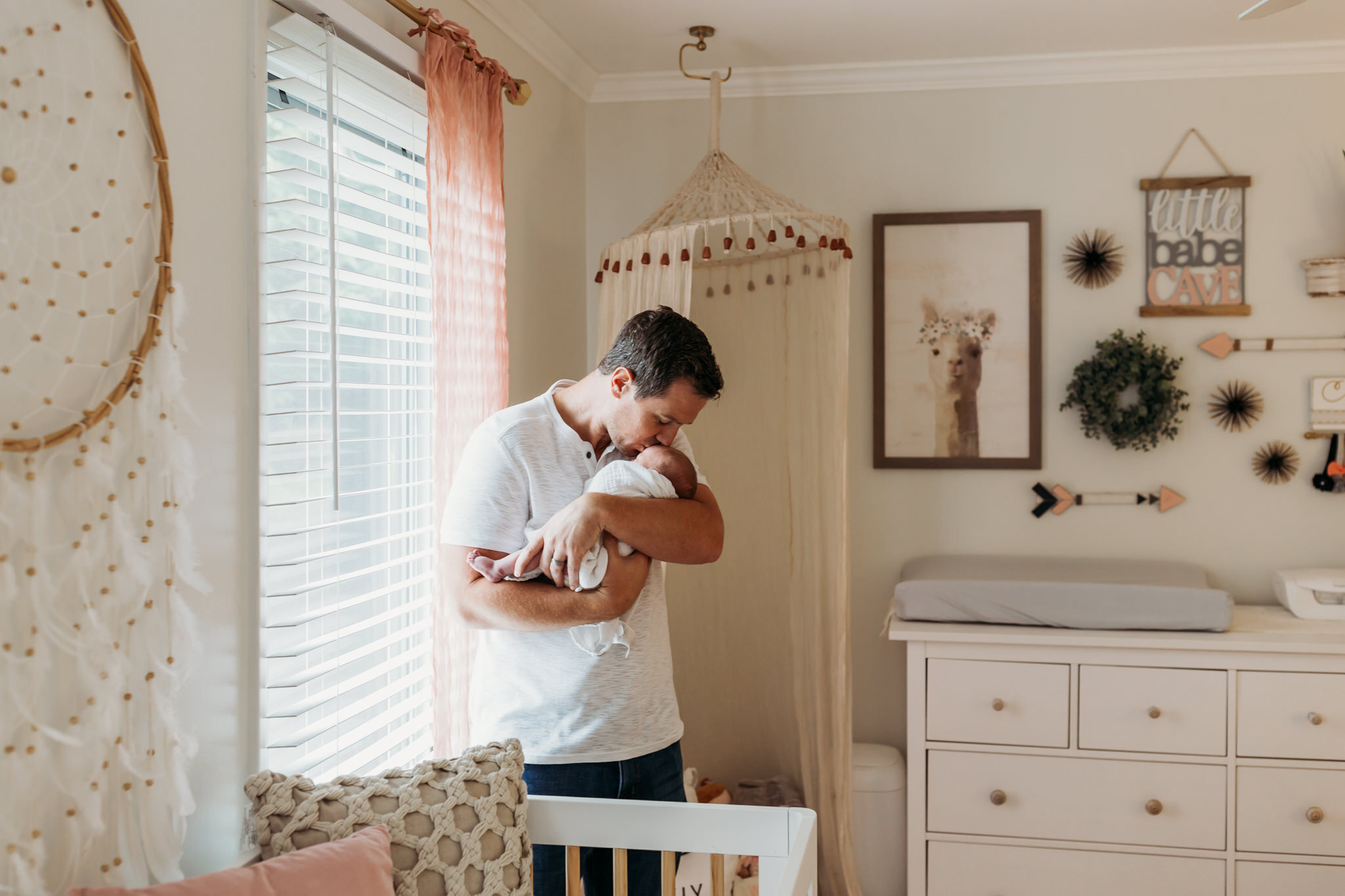 Dad kissing baby girl in nursery