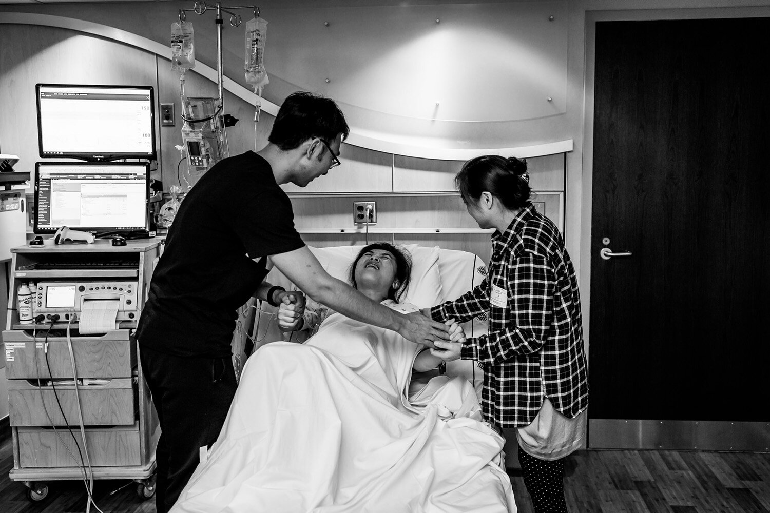 family comforts laboring mom in hospital birth