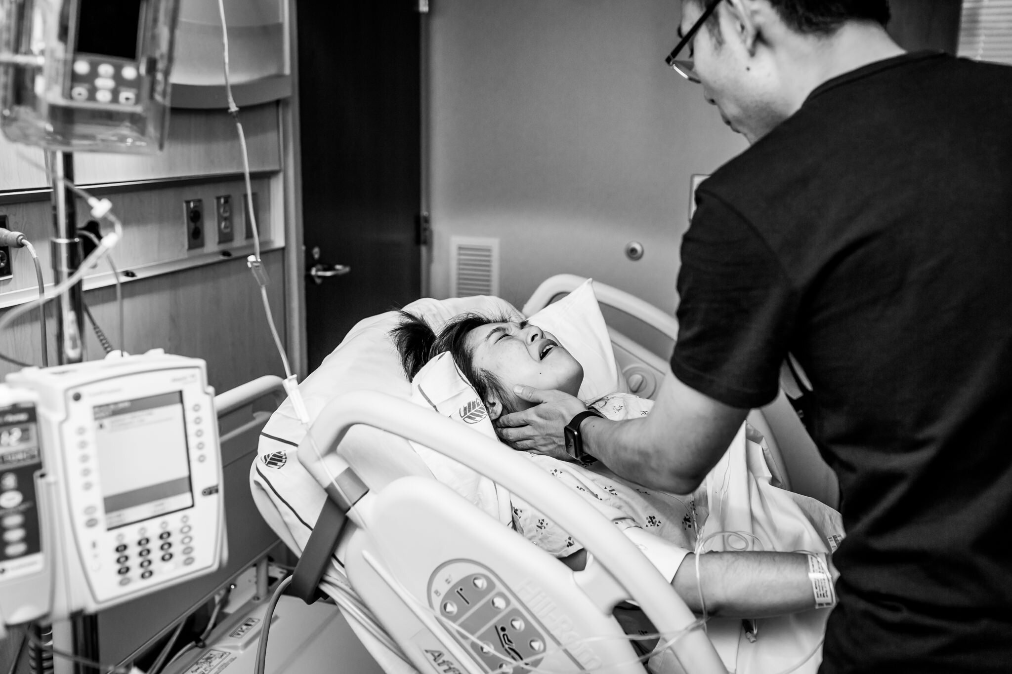 husband comforts wife during labor in hospital birth