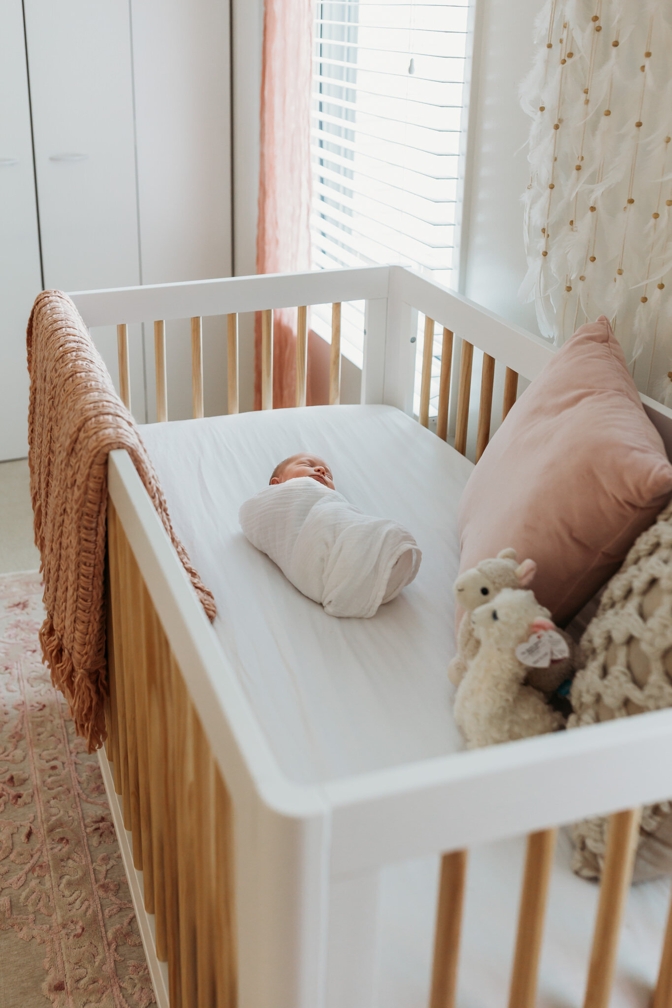baby laying in crib swaddled lifestyle newborn