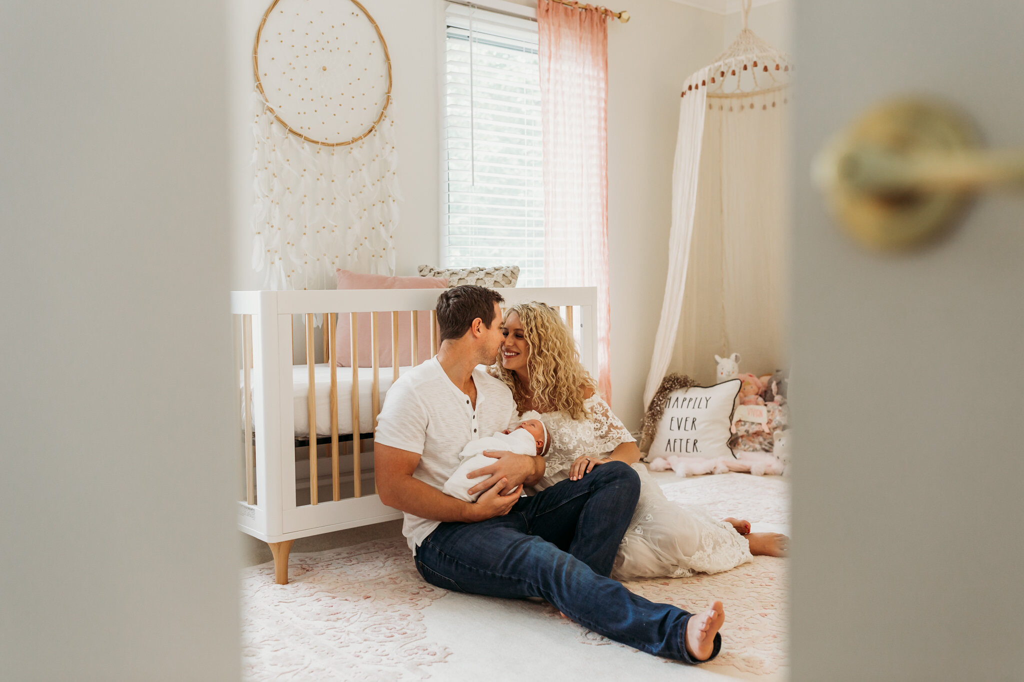 peek at new parents kissing in baby's nursery