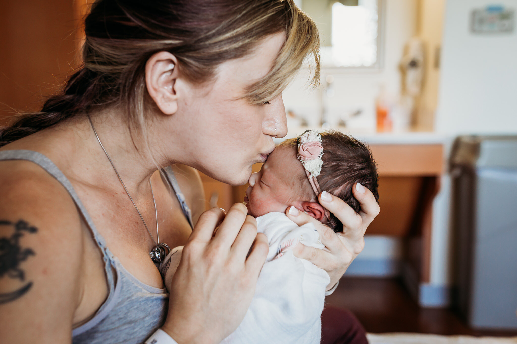 mom kissing newborn baby girl fresh 48 hospital