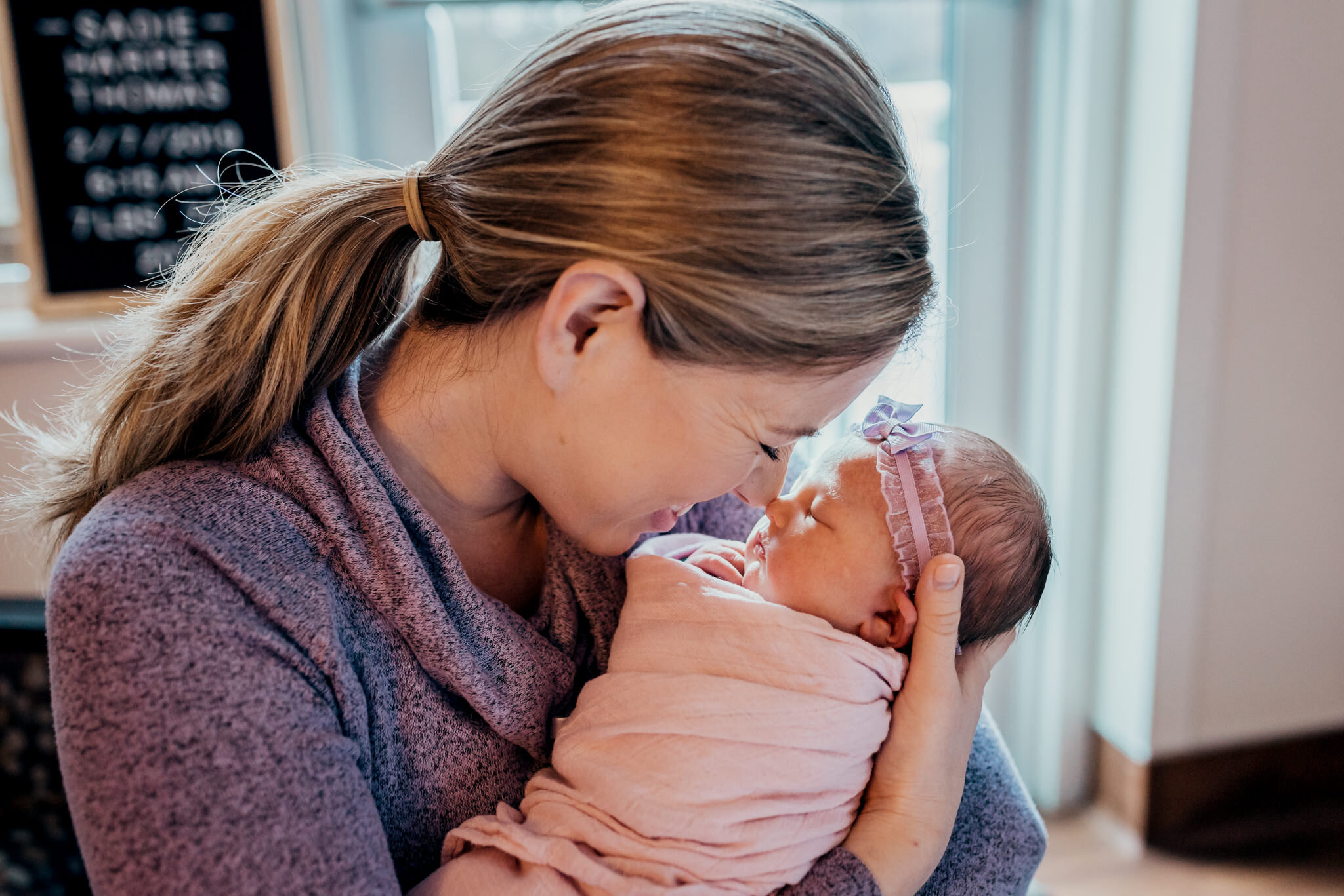 mom kisses baby girl in fresh 48 hospital