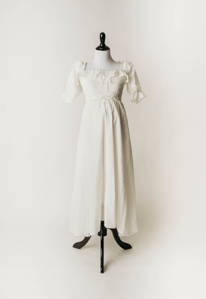 White milkmaid style a-line cotton maternity photoshoot dress with eyelit detail and ruffle puff sleeves