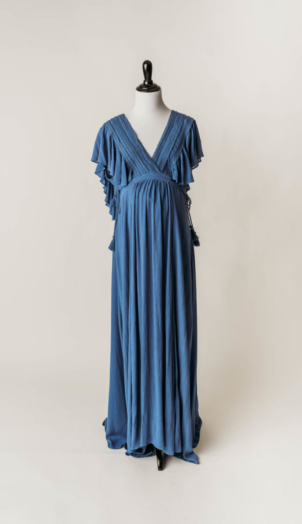 Blue deep V-neck maternity dress with intricate crochet lace trim on bodice with Ruffled butterfly sleeves and empire waist with Unique tassel rope ties at side