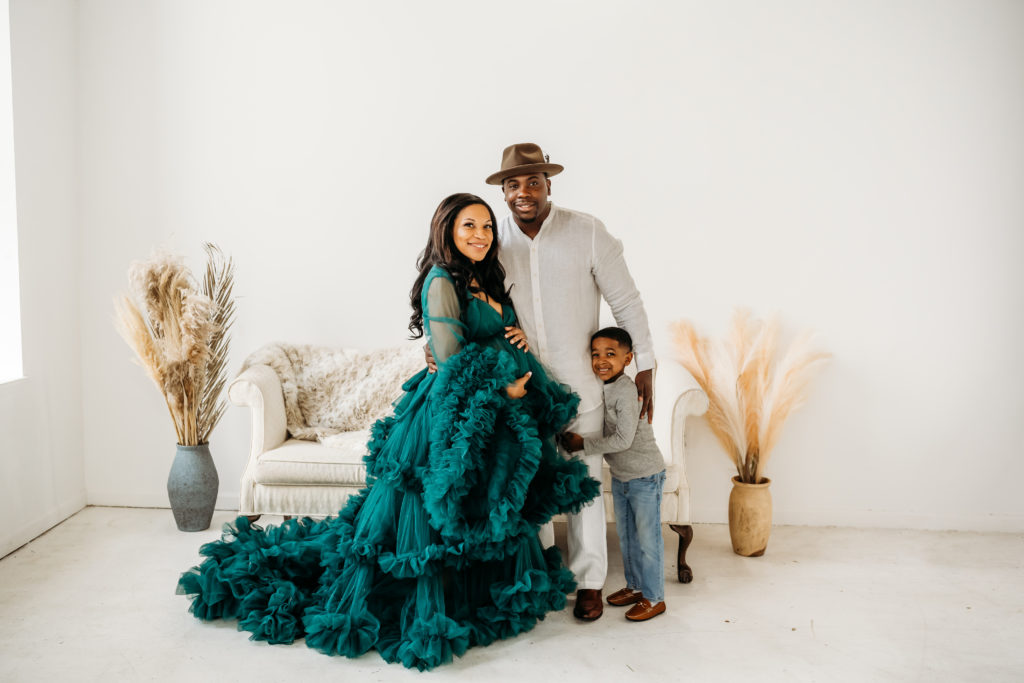 pregnant mom with family in teal tulle gown during studio maternity session