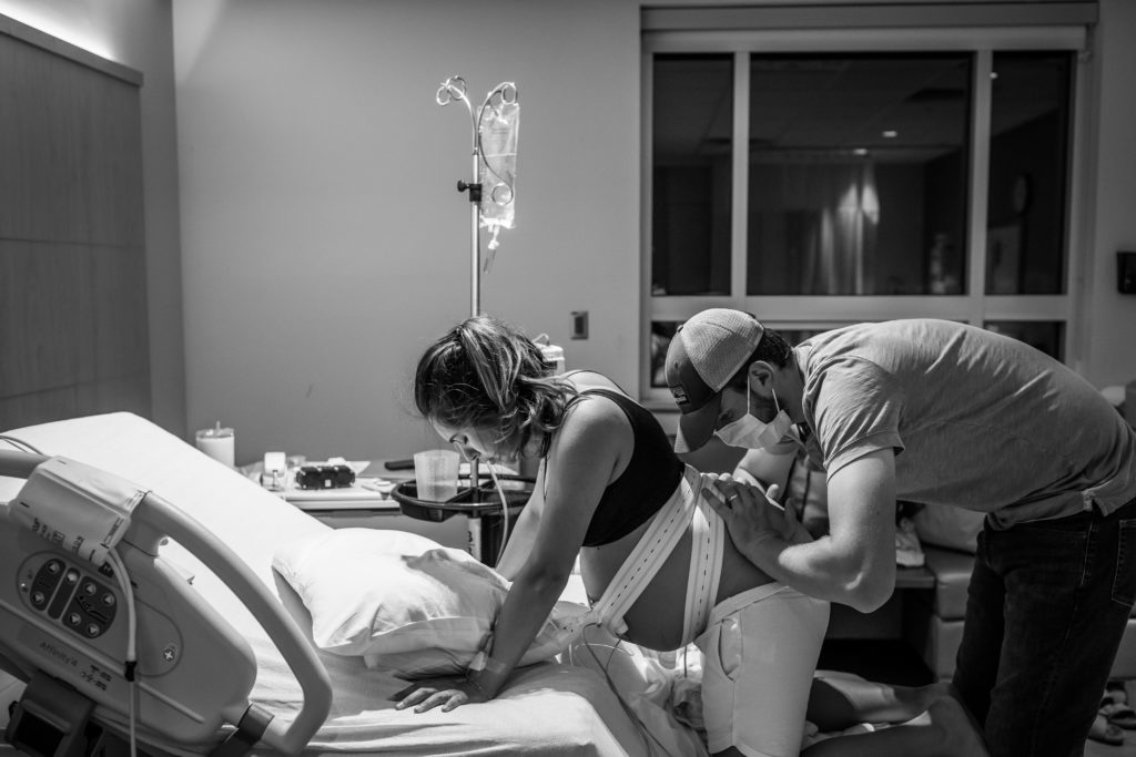 mom in labor getting counter pressure from her husband during hospital birth