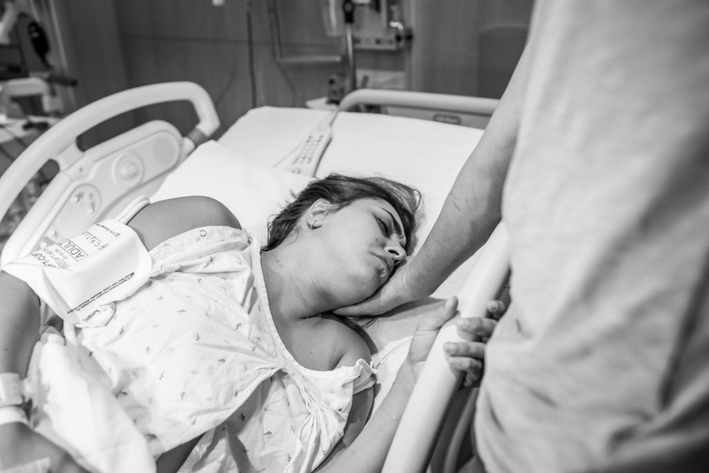 woman grimacing in pain during birth labor contraction
