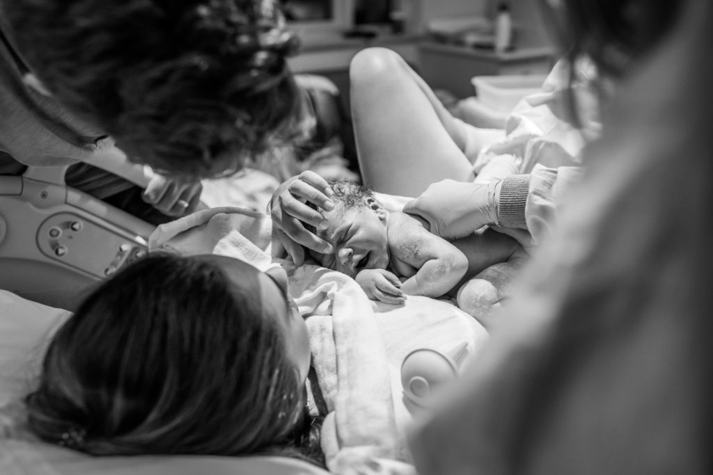 Mother touching newly born baby after hospital birth