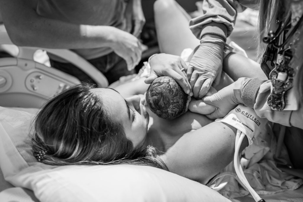 new mother doing skin to skin with newborn baby after birth
