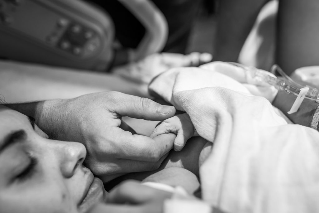 Close up of baby's hand holding on to dad's finger