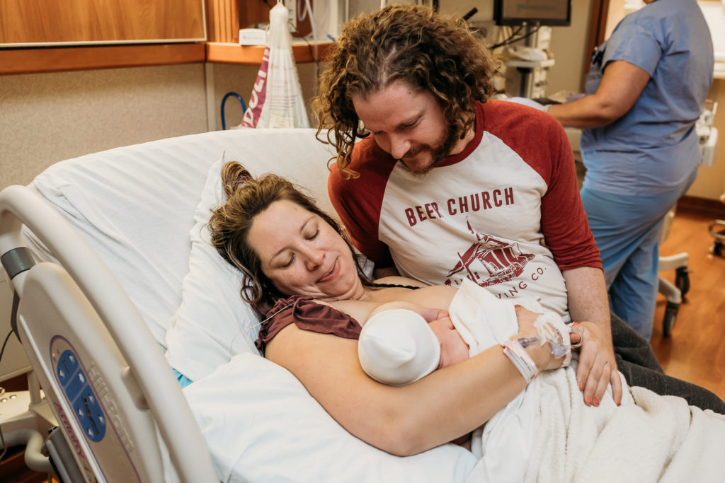 couple looking down at baby after delivery in hospital