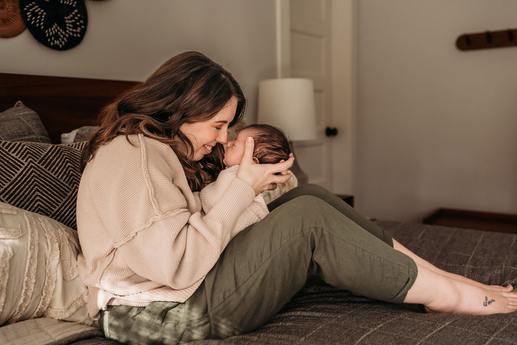 mom nuzzling baby on bed during lifestyle newborn session