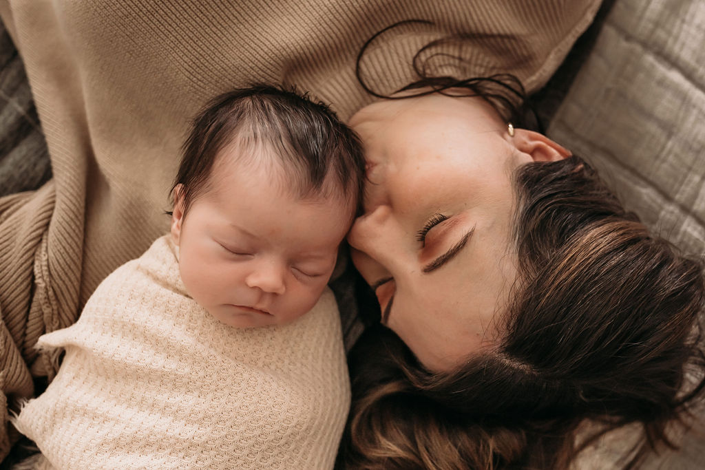 Close up of mom kissing newborn during lifestyle newborn session