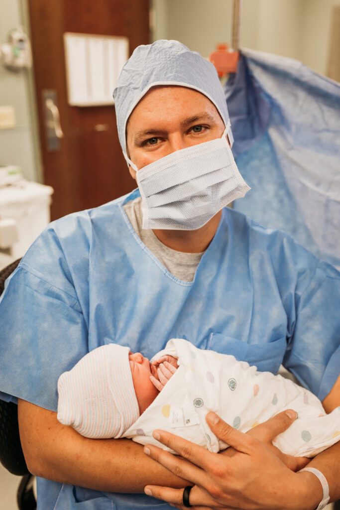 Portrait of dad holding baby during c-section
