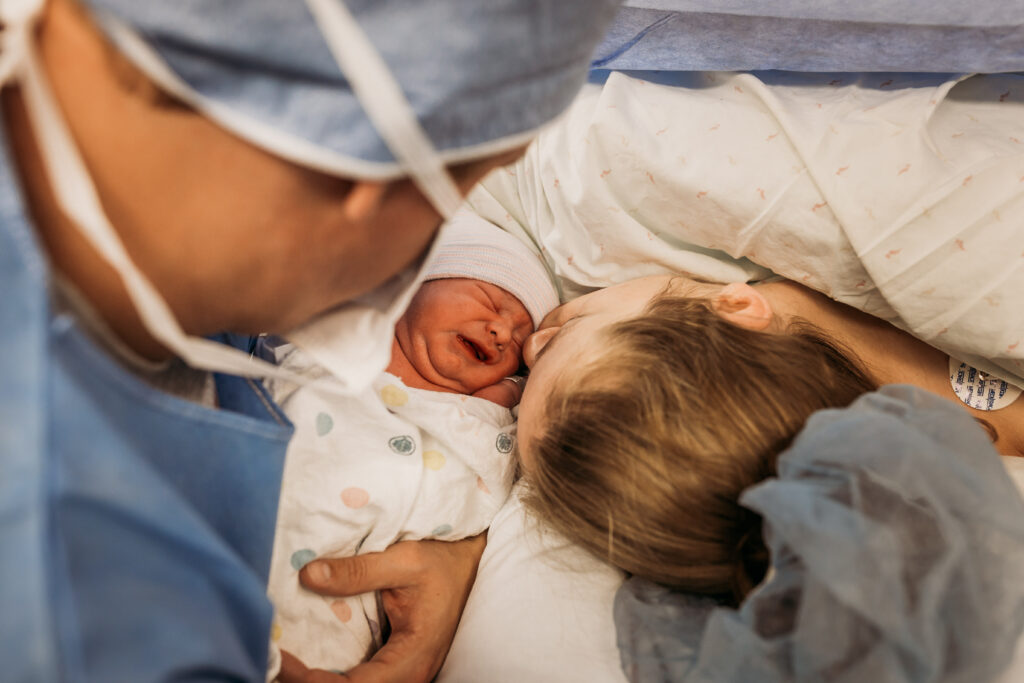 Mom kissing baby during c-section