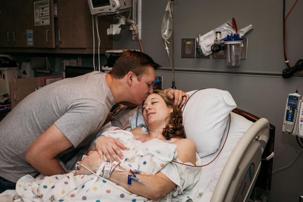 Dad kissing mom after c-section