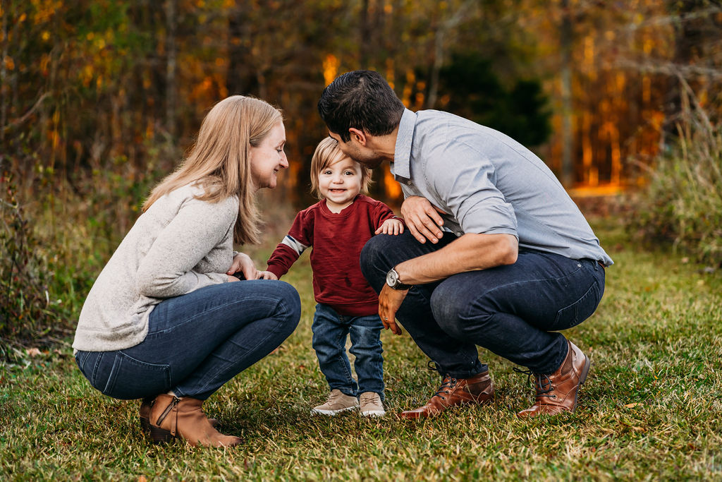 parents laughing with son in field