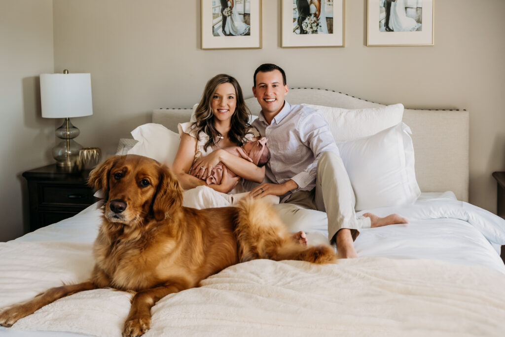 strong married couple in bed with newborn and dog
