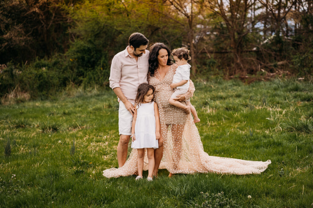 family standing in field in favorite maternity dress