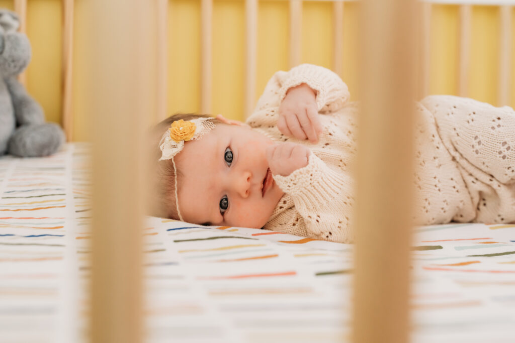up close of baby in crib wearing outfit from favorite newborn store