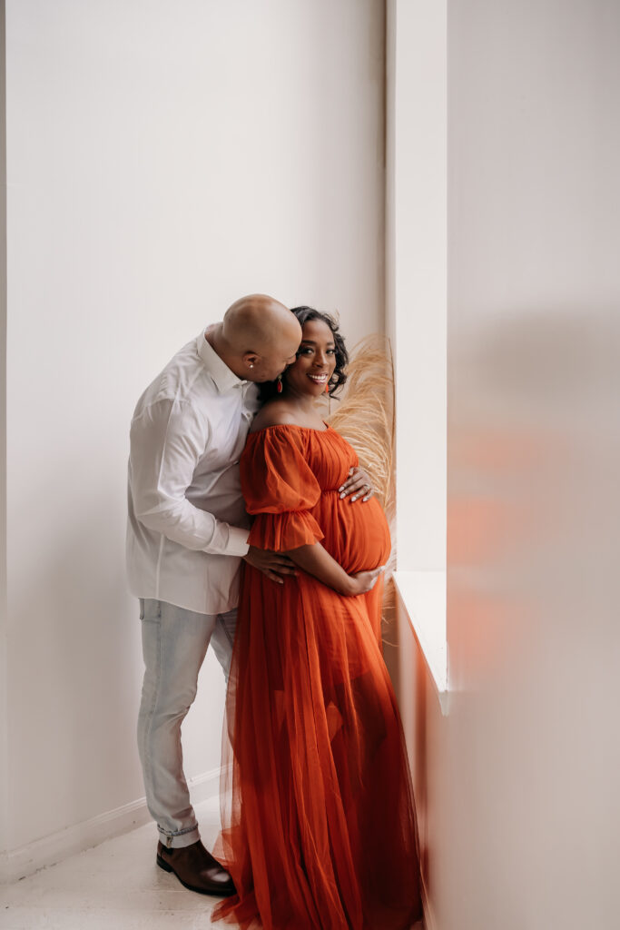 mother in orange maternity dress for maternity pregnancy cravings photoshoot