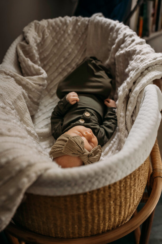 Baby sleeping in moses basket for sleep training essentials photoshoot