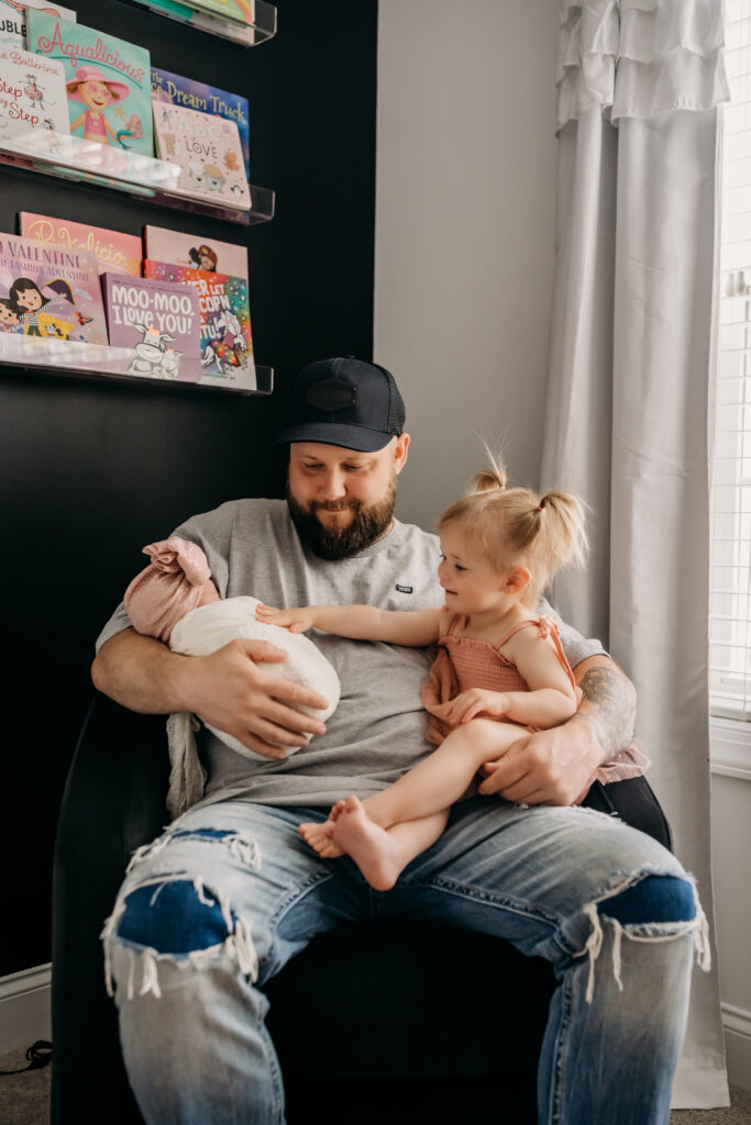 above shot of dad holding baby girl and little girl daughters