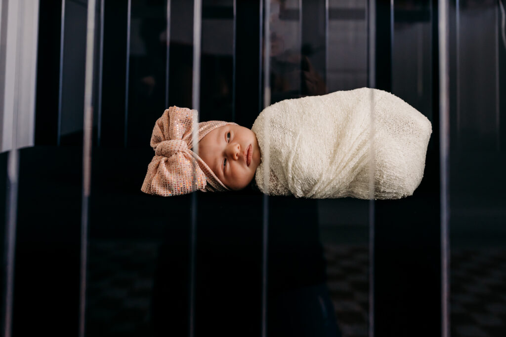 Close up of baby girl sleeping in clear crib