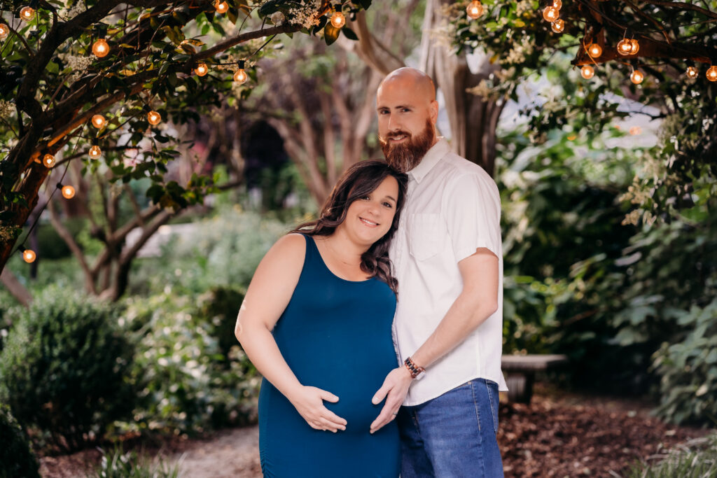 maternity couple embracing under lights for natural induction methods photoshoot