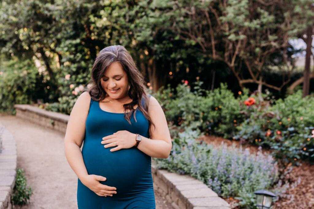 pregnant woman standing in garden for natural induction methods photoshoot